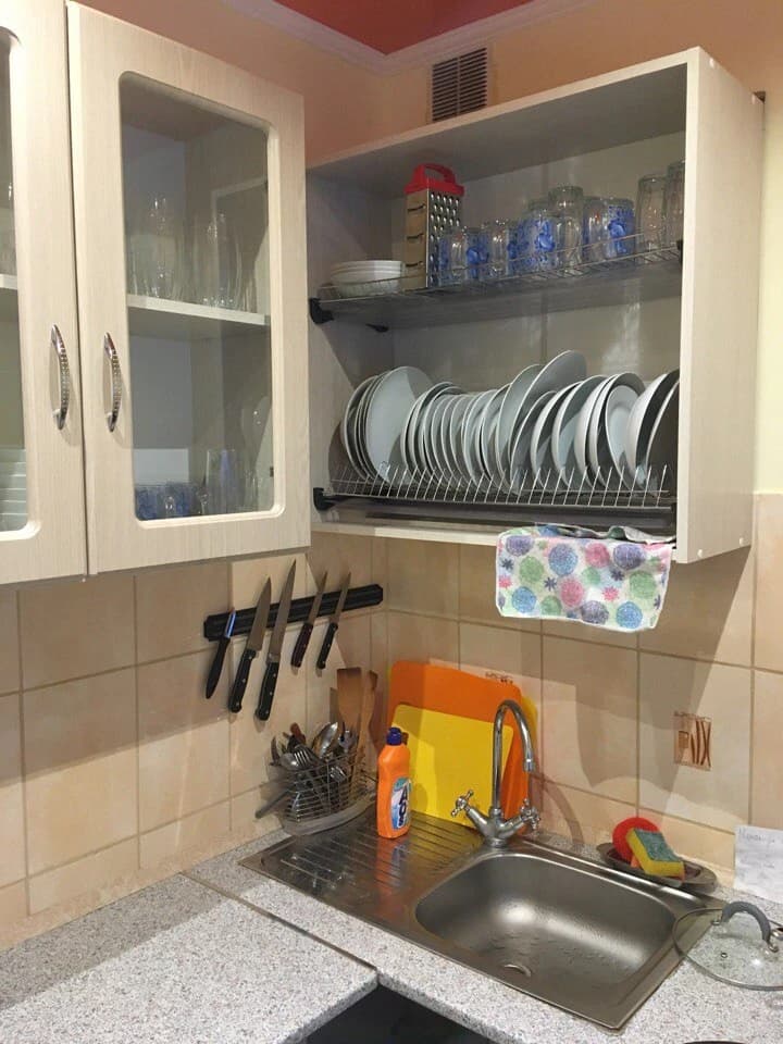 Кухонная зона хостела с мойкой, посудой и рабочей поверхностью