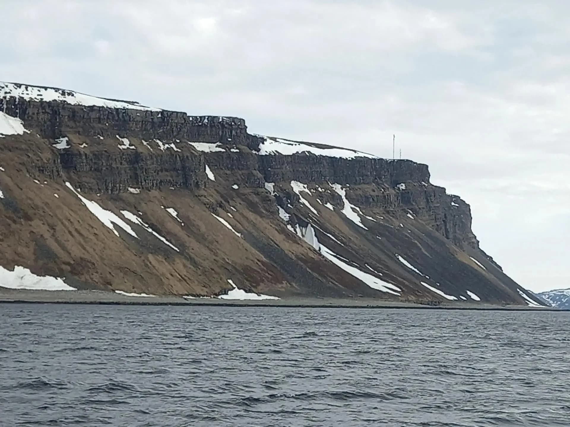 Плоская вершина над морем в пятнах снега